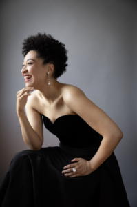 Soprano Julia Bullock in an evening gown laughing, joyful and at ease