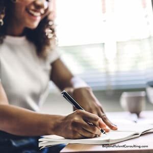 image of woman smiling as she writes
