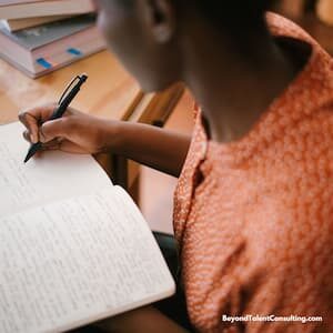 image: woman writing in a notebook
